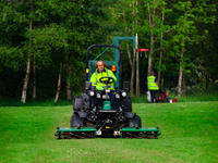 grounds maintenance contractor using Ransomes mower to cut grass