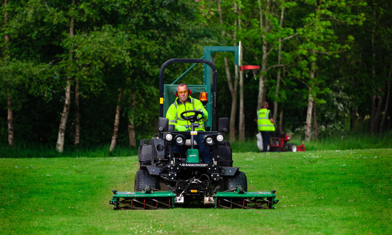 grounds maintenance contractor using Ransomes mower to cut grass