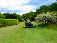 grounds maintenance contractor with a ransomes mower cutting grass