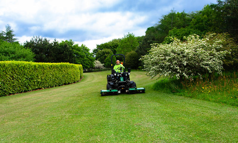 grounds maintenance contractor with a ransomes mower cutting grass